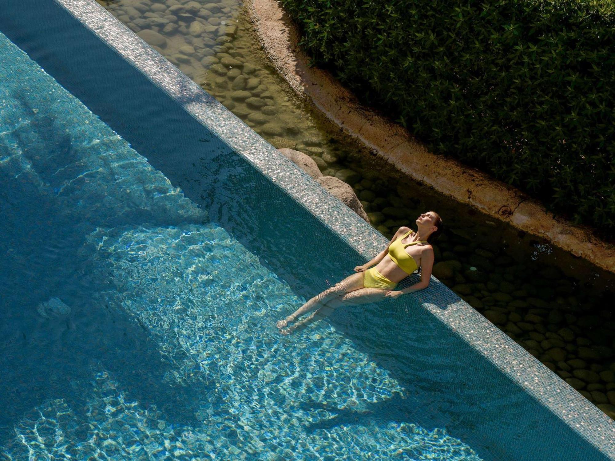 Sofitel Dubai The Palm Resort & Spa Esterno foto A woman sunbathing in a swimming pool